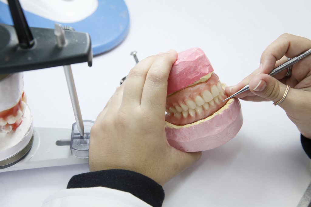 Dental technician working with dentures